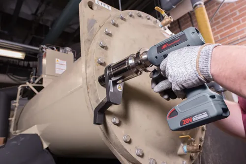 Person fæstner bolte på metaltank med brug af 20V momentnøglepistol af mærket Ingersoll Rand