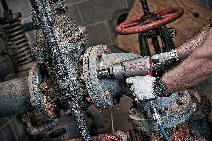  Person fæstner store bolte på rørsystem med Ingersoll Rand trykluft møtrikspænder 