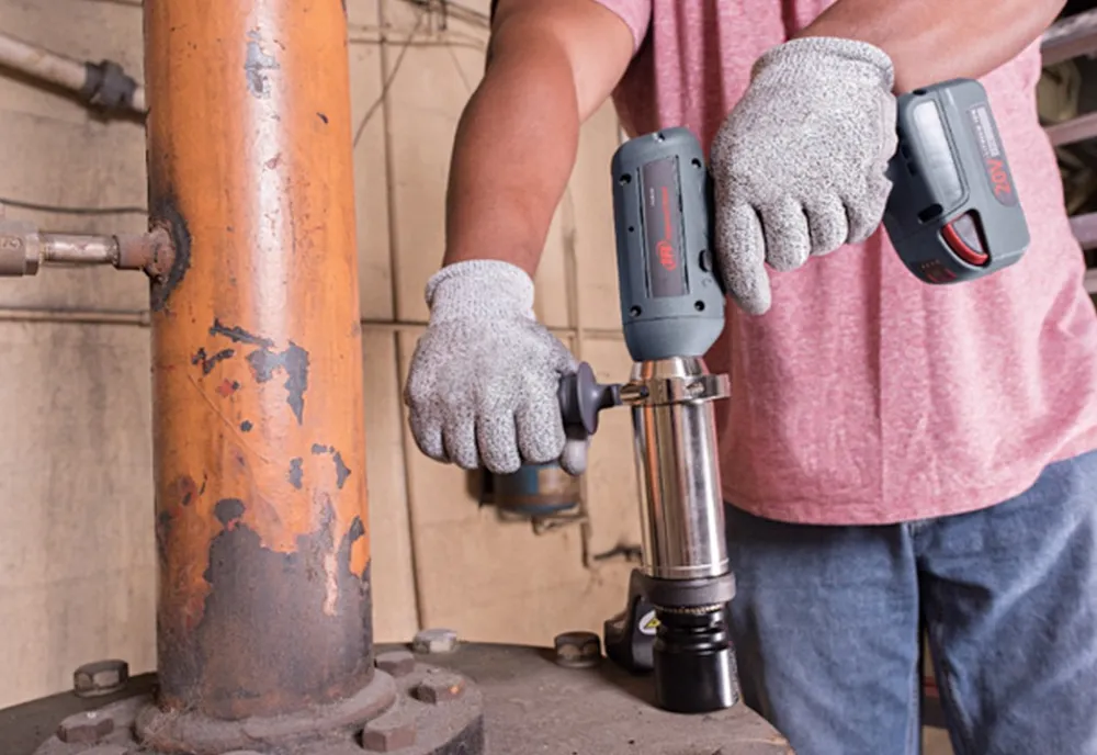  Mand i jeans og rød t-shirt arbejder med Ingersoll Rand akku momentnøglepistol